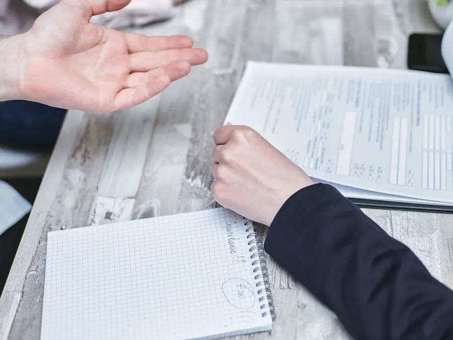 Dos personas revisando documentos en una mesa